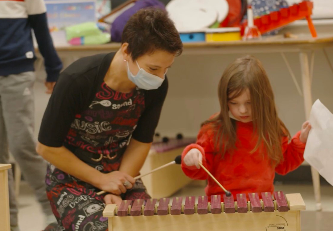 The music teacher accompanying her young student at the xylophone.